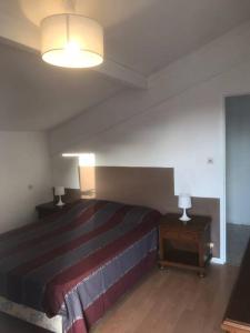 um quarto com uma cama e duas mesas de cabeceira com candeeiros em Louez l’étage d une maison basque à 5mn de Bayonne em Mouguerre