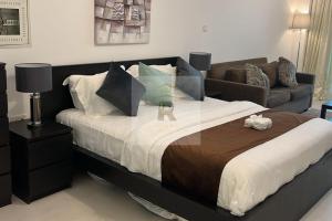 um quarto com uma cama grande e um sofá em Palm View East Jumeira - Studio Apartment em Dubai
