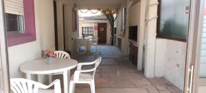 a table and chairs in a hallway with a table and a table and chairs at Lo de Antonio Departamentos in Valeria del Mar