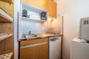 a small kitchen with wooden cabinets and a sink at Giffre in Samoëns