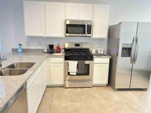 a kitchen with a stove and a stainless steel refrigerator at *Home away from home* 5 min away from Stadium in Phoenix