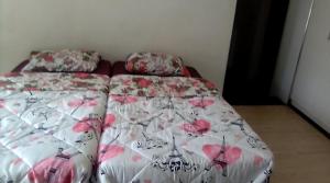 een bed in een kamer met een sprei met bloemen bij Inspire living in Benoni