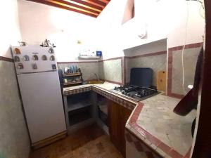 uma pequena cozinha com um fogão e um frigorífico branco em Entire Private House in Fez Medina! em Fez