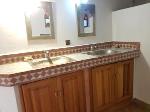 a bathroom with a double sink and two mirrors at Entire Private House in Fez Medina! in Fez