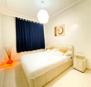 a bedroom with a large white bed and a window at Cosy greeny near PAUL harhoura in El Harhoura