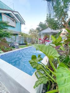 een zwembad voor een huis met planten bij Lovely Villa in Tagaytay with Pool & Full Taal View in Tagaytay