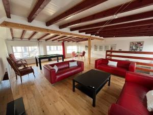 ホルツハイムにあるVilla avec piscine intérieureのリビングルーム(赤いソファ、テーブル付)