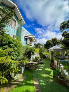 een tuin met een huis met een tafel en stoelen bij Lovely Villa in Tagaytay with Pool & Full Taal View in Tagaytay