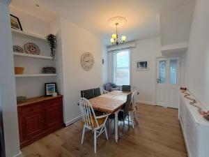 a dining room with a wooden table and chairs at 4 Bed house Sea Views Benji's by the beach in Morecambe