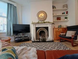 a living room with a fireplace and a tv at 4 Bed house Sea Views Benji's by the beach in Bare