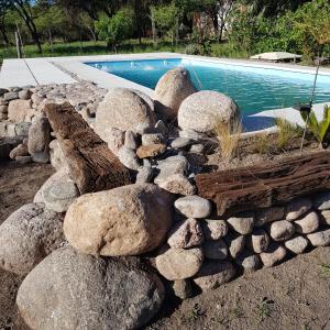 a rock retaining wall next to a swimming pool at Morada de encuentro in Capilla del Monte