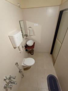 La salle de bains est pourvue de toilettes et d'un lavabo. dans l'établissement Sarvoday Eco Homestay, Sawantwadi, à Sawantwadi