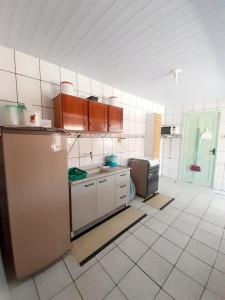 a kitchen with a refrigerator and a tiled floor at Pousada Mar Verde in Florianópolis
