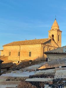 Une grande église en briques avec une cloche au-dessus dans l'établissement B&B Lidia Ricci, à Montegiorgio