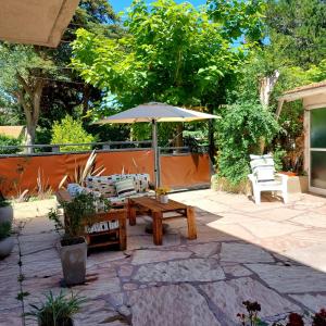 un patio con mesa y sombrilla en Lo de Antonio Departamentos en Valeria del Mar