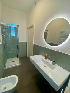 een badkamer met een wastafel, een toilet en een spiegel bij B&B Lidia Ricci in Montegiorgio