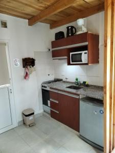 una pequeña cocina con fregadero y microondas en Catedral View minimo 4 noches en San Carlos de Bariloche