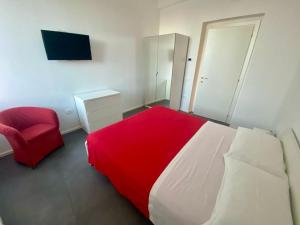 a bedroom with a red bed and a red chair at B&B Lidia Ricci in Montegiorgio