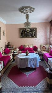 a living room with pink furniture and a table at appartement belle in Meknès
