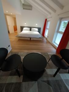 a bedroom with a bed and two chairs at La Barchessa Rooms In Trento in Trento