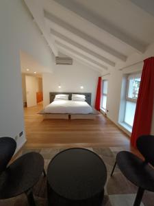 a bedroom with a bed and two chairs at La Barchessa Rooms In Trento in Trento