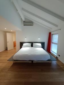 a bedroom with a large white bed in a room at La Barchessa Rooms In Trento in Trento