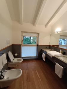 a bathroom with two toilets and a sink and a window at La Barchessa Rooms In Trento in Trento
