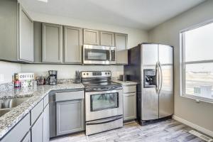 una cocina con electrodomésticos de acero inoxidable y una ventana en Spacious Utah Home 34 Mi to Salt Lake City, en Tooele