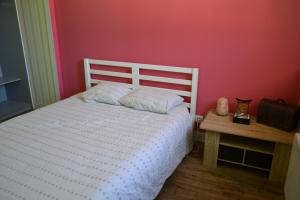 een slaapkamer met een wit bed en een rode muur bij Grande chambre d'hôte avec piscine chauffée et Jacuzzi à disposition in Chef-Boutonne