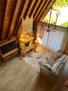 a living room with a couch and a fireplace at Chalé Villa Felicitá (Itália) in Pomerode +9 photos