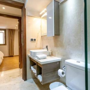 ein Bad mit einem Waschbecken und einem WC in der Unterkunft Appartement Cosy Residence avec 2 Piscines in Marrakesch