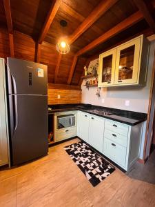 uma cozinha com um frigorífico em aço inoxidável e tectos em madeira em Chalé Villa Felicitá (Itália) em Pomerode