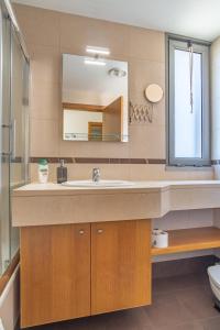 een badkamer met een wastafel en een spiegel bij Barreiros Residence View in Funchal