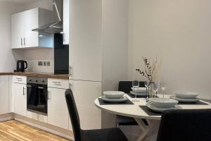 曼徹斯特的住宿－Stunning Two Bedroom Apartment，一间带桌椅的厨房和一间用餐室