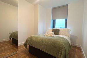 曼徹斯特的住宿－Stunning Two Bedroom Apartment，一间卧室配有一张带窗户和镜子的床