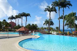 ein Swimmingpool in einem Resort mit Palmen in der Unterkunft VUE MER Site paradisiaque Superbe décoration in Sainte-Luce
