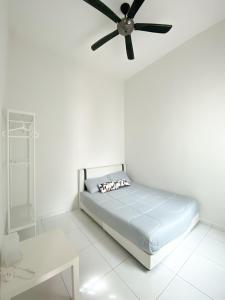 een witte kamer met een bed en een plafondventilator bij Cosy House For Family Or Group In Bukit Beruang Melaka in Kampong Pengkalan Batu