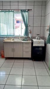 a kitchen with a sink and a window at Pousada Mar Verde in Florianópolis