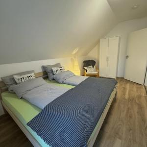 ein Schlafzimmer mit einem großen Bett mit blauer Bettwäsche in der Unterkunft Ferienwohnung Auf Der Höll 