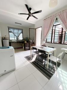 uma sala de jantar com uma mesa e uma ventoinha de tecto em Cosy House For Family Or Group In Bukit Beruang Melaka em Kampong Pengkalan Batu