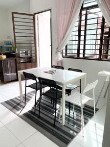 een witte eettafel en stoelen in een kamer bij Cosy House For Family Or Group In Bukit Beruang Melaka in Kampong Pengkalan Batu
