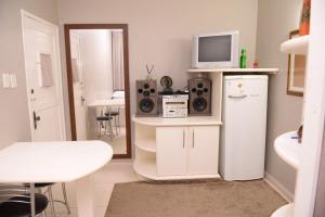 a living room with a tv on top of a refrigerator at Otimo Flat c WI-FI no centro de Santa Rosa in Santa Rosa