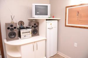 een woonkamer met een televisie en een witte koelkast bij Otimo Flat c WI-FI no centro de Santa Rosa in Santa Rosa