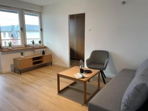 ein Wohnzimmer mit einem Sofa, einem Tisch und einem Stuhl in der Unterkunft P15 in Suwałki