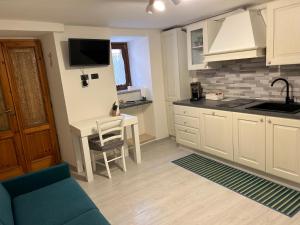 cocina con sofá y mesa con TV en Casa Martino, en Norcia