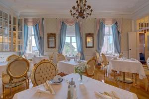 a dining room with tables and chairs and a chandelier at Palacio das Especiarias in Lisbon