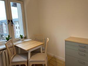 eine Küche mit einem Tisch und Stühlen sowie einem Fenster in der Unterkunft P15 in Suwałki