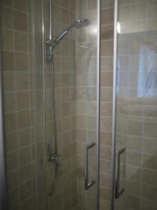 a shower stall with a glass door with a shower at Nature, Mer, Golf & Decouvertes... in Plouha