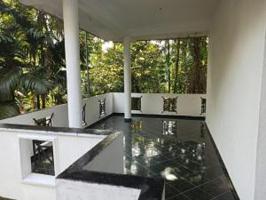 Habitación con mesa, sillas y árboles en 4Seasons Holiday Home en Ratnapura