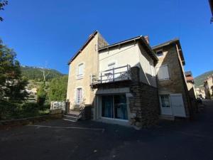 un gran edificio de ladrillo con balcón. en Chambres d'Hôtes La Petite Boynarde, en Rivière-sur-Tarn